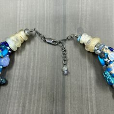 This necklace was designed to emulate ocean waves. I combined many many different beads to create this 6 strand necklace. In this necklace you will find czech glass, labradorite, ceramic beads, lapis, cultured sea glass, seed beads, sodalite, apatite, dragon vein agate, and many more. The ends of the necklace are ancient glass trade beads. The necklace is finished in sterling silver with a lobster clasp and extender chain.This necklace is adjustable from 20” to just under 22”.It weighs 145g. Unique Multi-strand Gemstone Beads, Artisan Blue Labradorite Necklace, Artisan Blue Double Strand Beaded Necklace, Blue Multi-strand Czech Glass Jewelry, Blue Multi-strand Jewelry With Czech Glass, Artisan Blue Beaded Necklaces With Czech Glass, Artisan Blue Beaded Necklace With Czech Glass, Artisan Blue Czech Glass Beaded Necklaces, Labradorite Round Beads Necklace