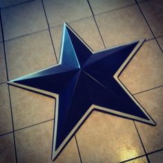 a blue and white star on the floor in a room with tile floors that has brown grouting