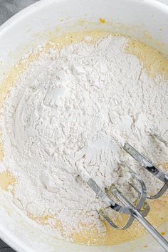 a mixing bowl filled with flour and whiskers