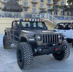 two jeeps parked next to each other in front of a beach side resort building