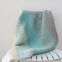 a crocheted blanket sitting on top of a white chair