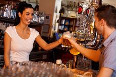 a man and woman are shaking hands at the bar