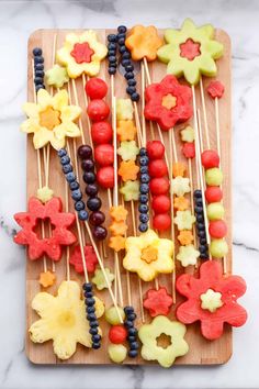 fruit skewers are arranged on a cutting board