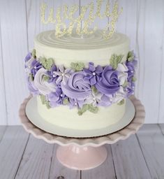 a white cake with purple and green flowers on top