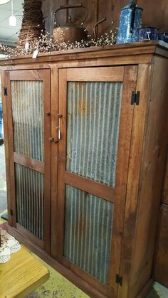 an old wooden cabinet with glass doors in a room filled with junk and other items