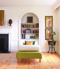 a living room filled with furniture and bookshelves next to a white fire place