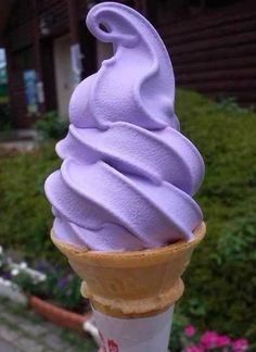 an ice cream cone with purple icing on top