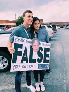 a man and woman standing in front of a white truck holding a sign that says false