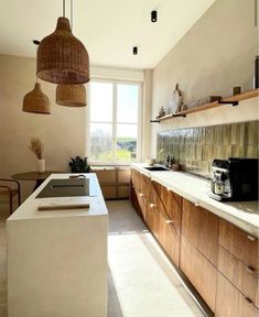 a kitchen with wooden cabinets and white counter tops next to a large window that looks out onto the countryside