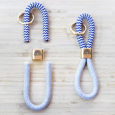 two blue and white roped objects on a wooden surface, one with gold hardware