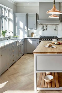 a kitchen with wooden floors and gray cabinets