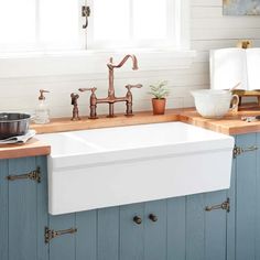 a kitchen sink sitting under a window next to a counter