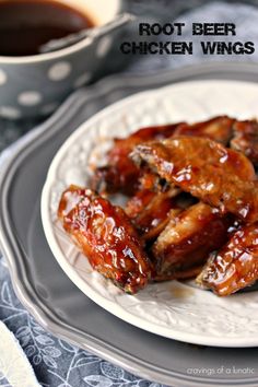 a white plate topped with chicken wings next to a cup of coffee