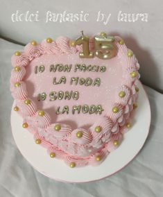 a pink heart shaped cake with the number thirteen on it's side and gold beads around the edges