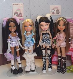 four dolls are standing next to each other