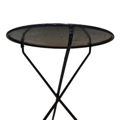 a glass table with metal legs and an iron frame on the top, against a white background