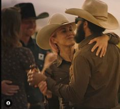 a man in a cowboy hat hugging a woman