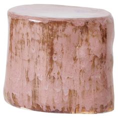 a pink and brown vase sitting on top of a wooden table with rusted paint