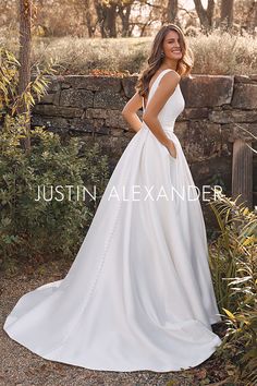 a woman in a white wedding dress posing for the camera with her hands on her hips