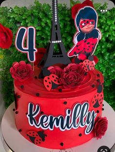 a red cake decorated with the eiffel tower and ladybug