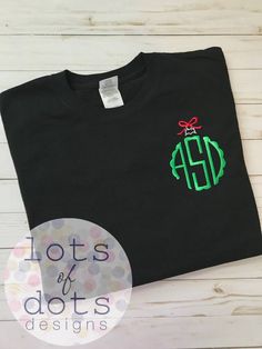 a black t - shirt with green and red monogrammed christmas ornament