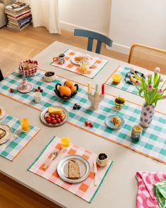 the table is set with plates, cups and fruit