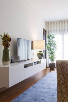 a living room filled with furniture and a flat screen tv on top of a entertainment center