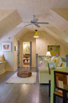 a living room filled with furniture and a ceiling fan mounted to the side of a wall