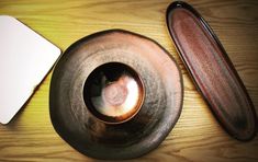 a wooden table topped with a metal bowl and plate