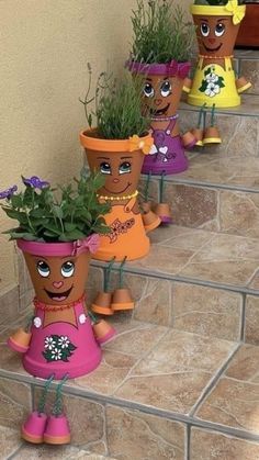 several flower pots with plants in them sitting on the steps