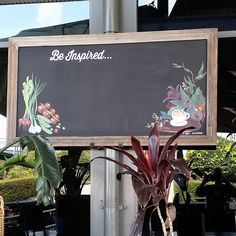 there is a sign that says be inspired with flowers and plants in front of it