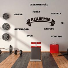 a gym room with dumbbells and wall decals on the walls in spanish