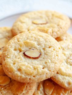 some cookies are stacked on top of each other with almonds in the middle and one has a bite taken out of it