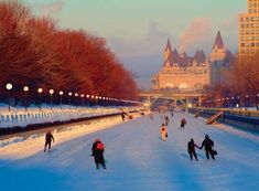 many people are skating on the ice in front of a castle