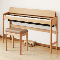 a wooden piano sitting on top of a hard wood floor next to a bench and stool