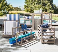 outdoor furniture with blue and white striped towels on the back patio, next to a swimming pool