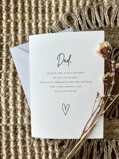 a card with the words dad written on it next to some dried flowers and a piece of paper