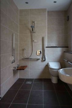 a bathroom with two sinks, a toilet and a shower head mounted to the wall