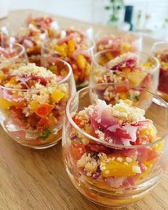 small bowls filled with food sitting on top of a wooden table