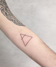 a man's arm with a triangle tattoo on it