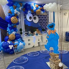 the balloon arch is decorated with blue balloons and an elmo cookie monster on it