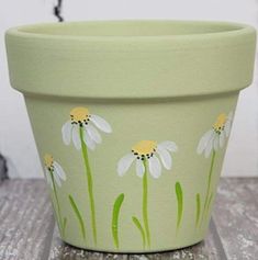 a painted flower pot sitting on top of a wooden table