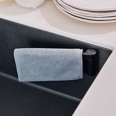 a towel is hanging on the handle of a kitchen sink with plates in the background