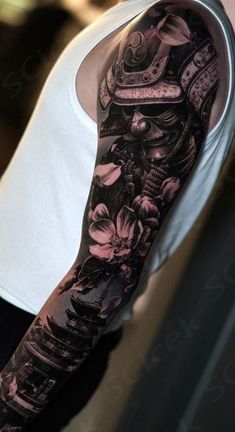 a man's arm covered in black and grey ink with flowers on the sleeve