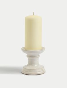 a white candle sitting on top of a table