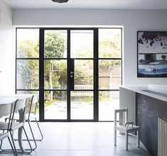 a kitchen with an open door leading to a patio area and outside dining room areas