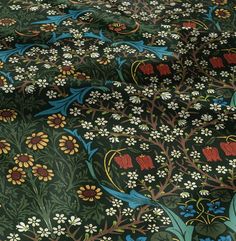 the fabric is very colorful and has many designs on it, including flowers and leaves