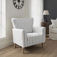 a living room with a clock on the wall and a chair in front of it