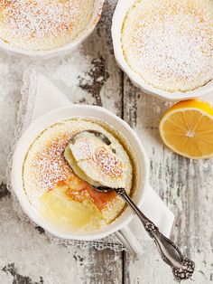 two bowls filled with orange custard and topped with powdered sugar