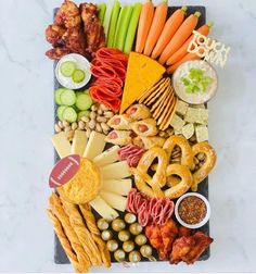 a platter filled with cheese, crackers, pretzels and meats